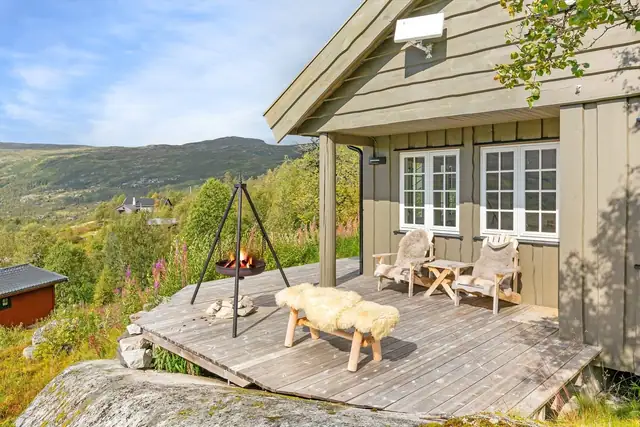 Utsikten fra terrassen strekker seg over dalen og fjellene, og gir en følelse av å være i ett med naturen