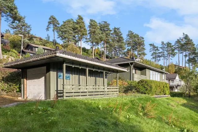 Den frittstående garasjen har plass til én bil. Det er også opplyst om parkering på egen tomt.